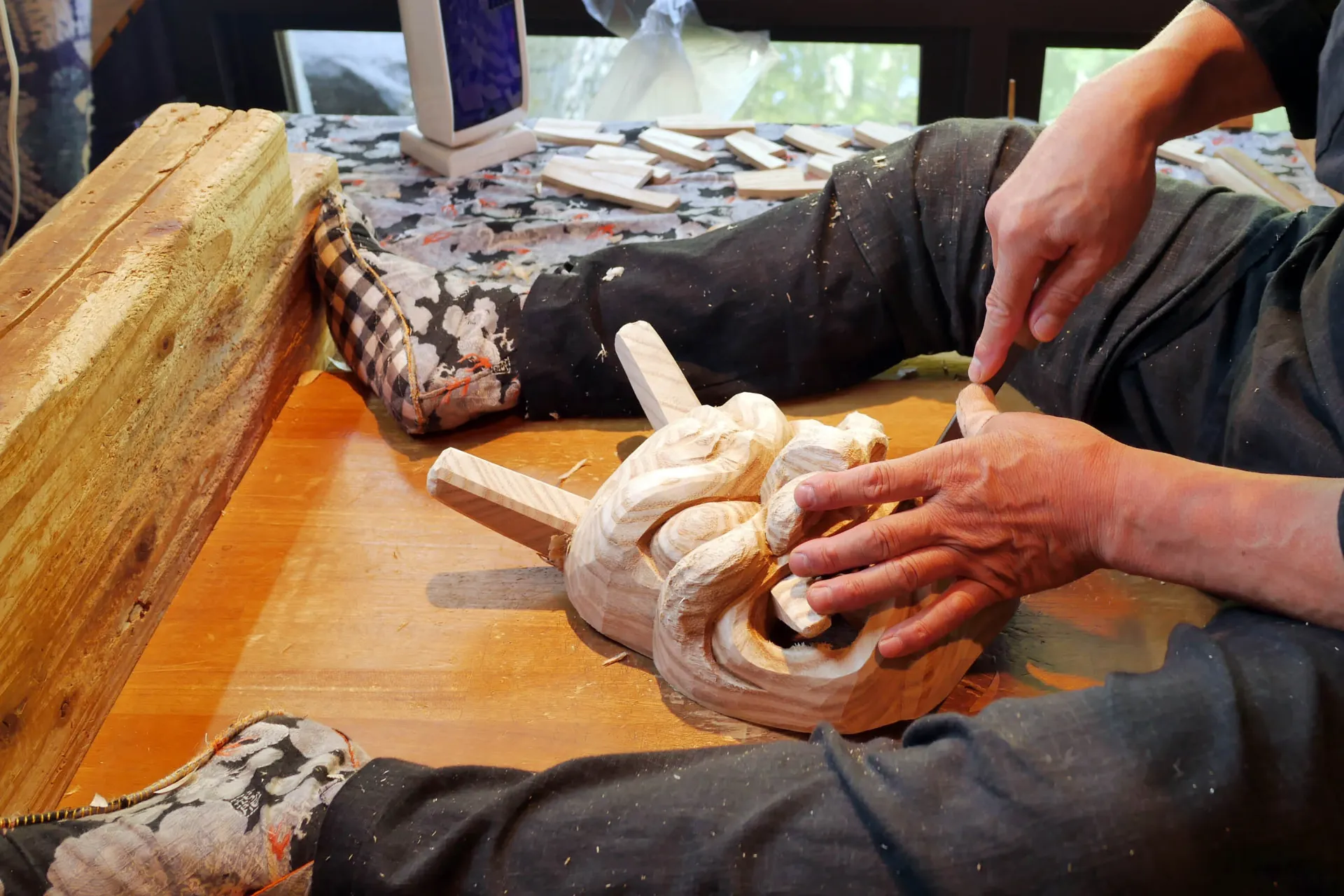 Japoński rzemieślnik rzeźbi tradycyjną drewnianą maskę