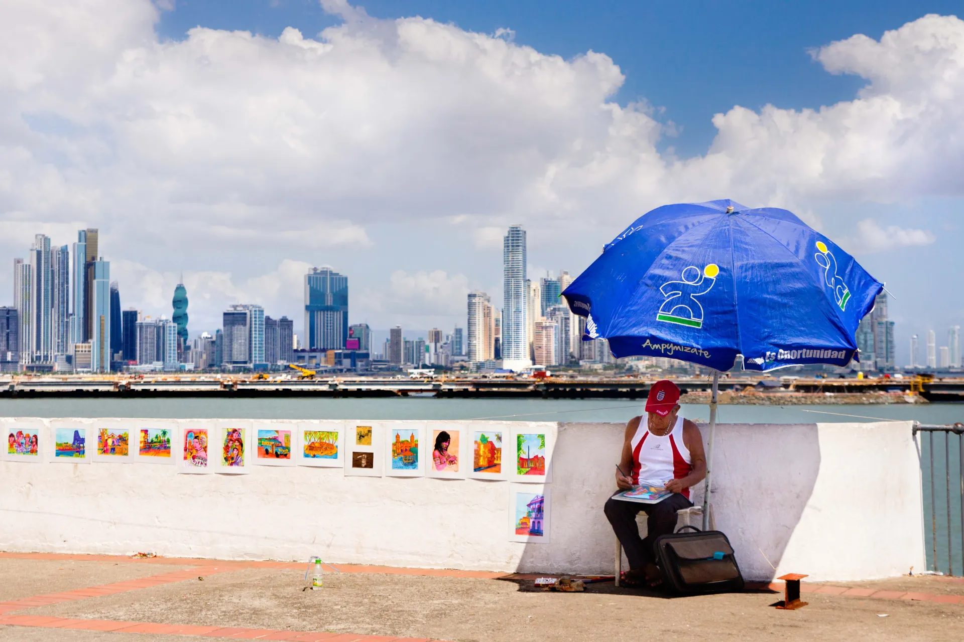 Sprzedawca uliczny odpoczywa w cieniu z widokiem na panoramę Panamy