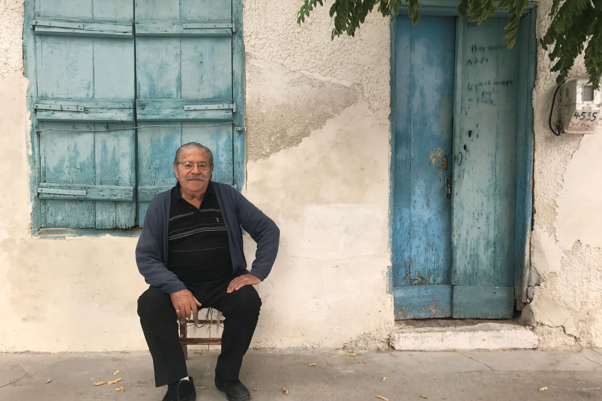 Starszy Grek pozuje przed swoim domem Starszy Grek pozuje przed swoim domem