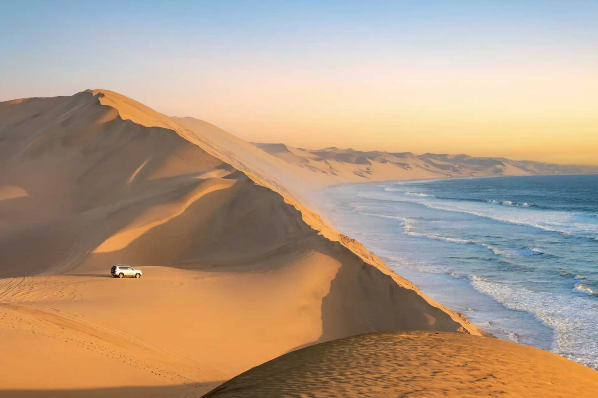 Sandwich Harbour w Namibii, gdzie wysokie wydmy opadają bezpośrednio do morza