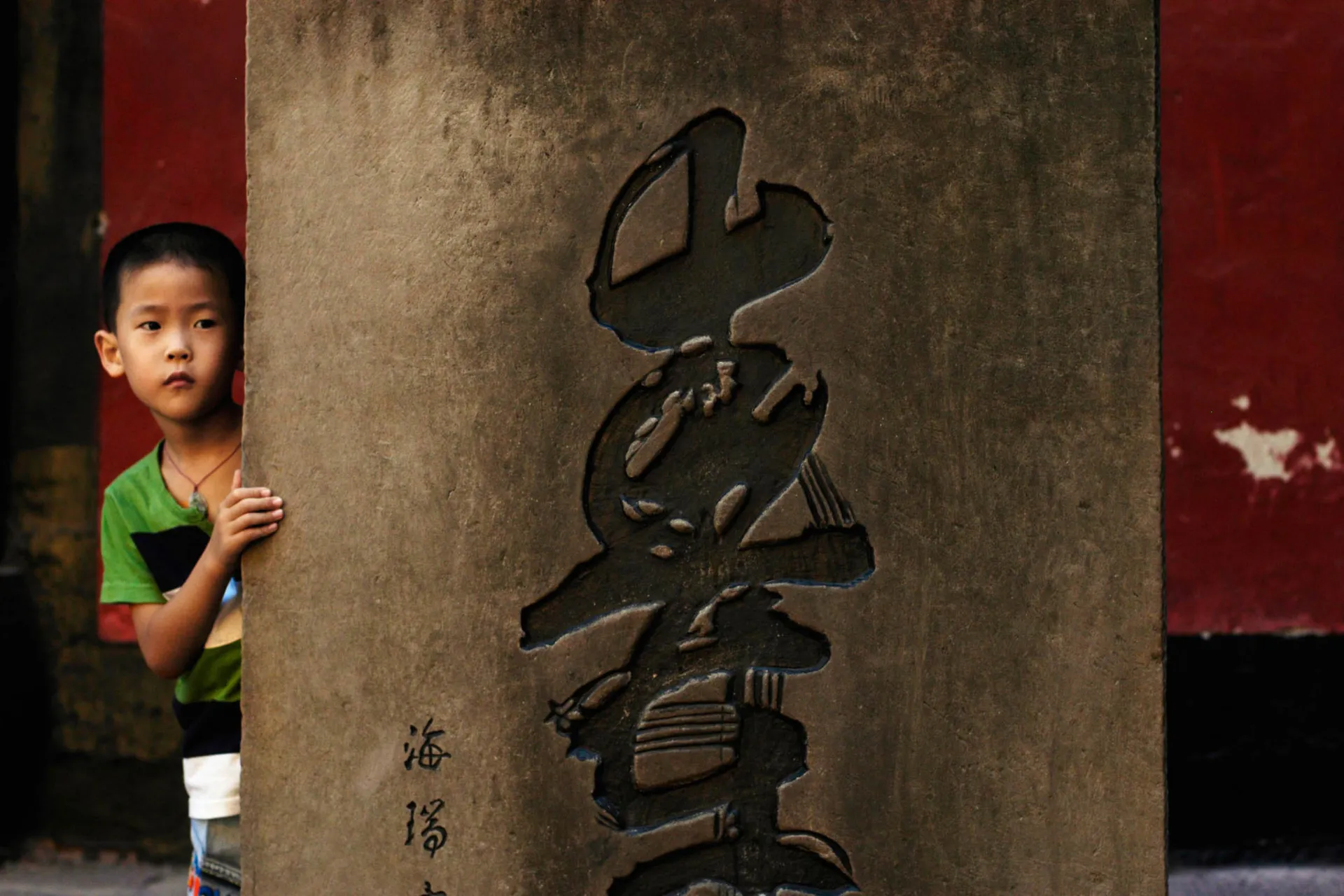 Chłopiec przy kolumnie – napis „góra” po chińsku