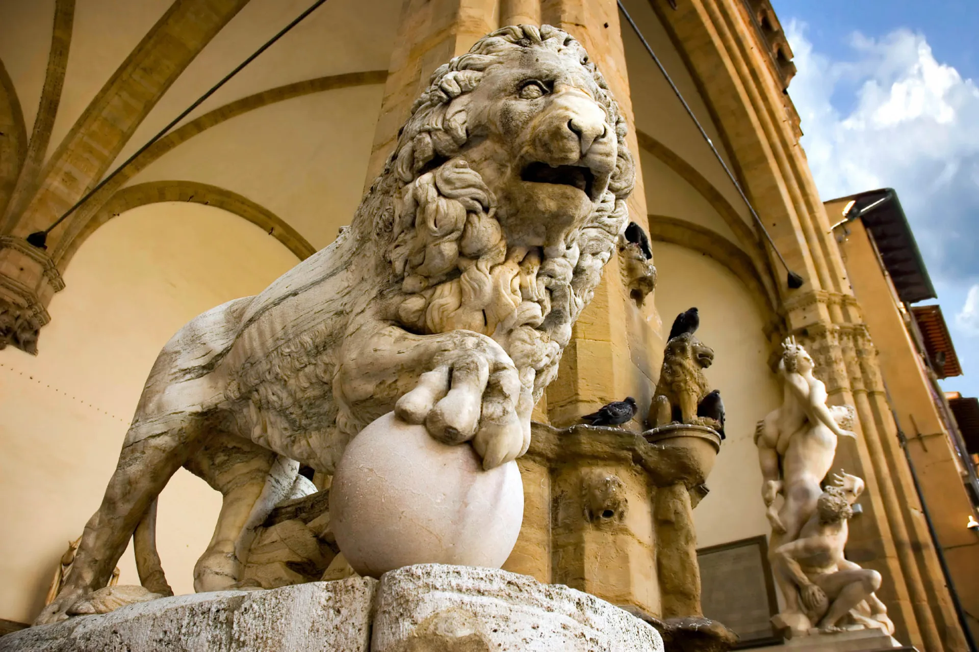 Rzeźba lwa z marmuru otoczona artystycznymi detaljami