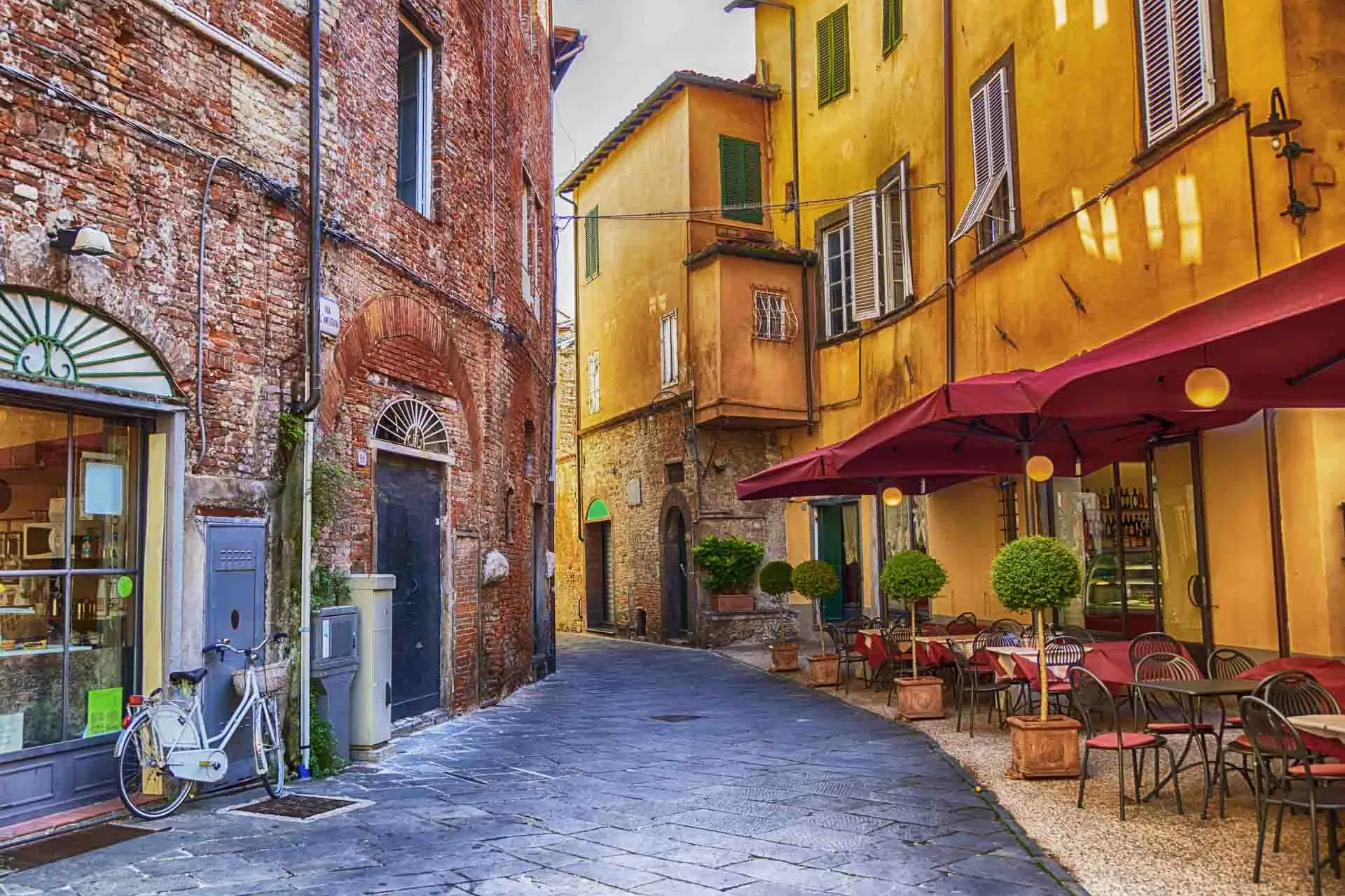 Urokliwa uliczka w Lukce z kawiarnią i kolorowymi domami