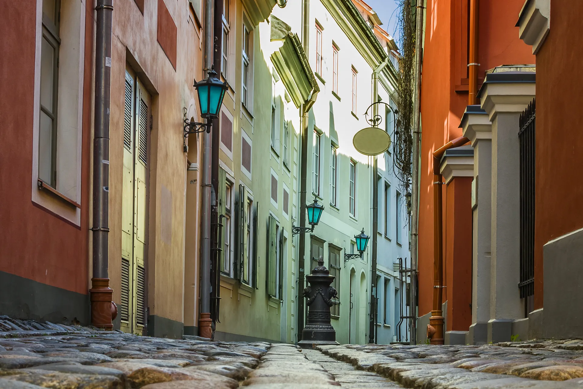 Wąska brukowana uliczka z kolorowymi fasadami w starej Rydze Wąska brukowana uliczka z kolorowymi fasadami w starej Rydze