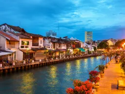 Wieczorna atmosfera nad rzeką Malacca z zabytkowymi domami, kawiarniami i oświetloną promenadą