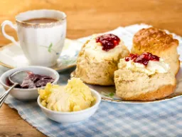 Cream tea z Devon i Cornwall – ciepłe bułeczki z clotted cream, dżemem i herbatą Cream tea z Devon i Cornwall – ciepłe bułeczki z clotted cream, dżemem i herbatą