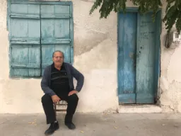 Starszy Grek pozuje przed swoim domem Starszy Grek pozuje przed swoim domem