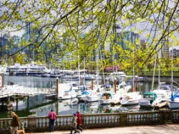Wiosenny nastrój w Vancouver Harbour z łodziami, promenadą i panoramą miasta w tle