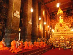 Mnisi modlący się przed Złotym Buddą w świątyni Wat Pho, Bangkok