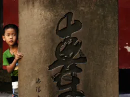 Chłopiec przy kolumnie – napis „góra” po chińsku