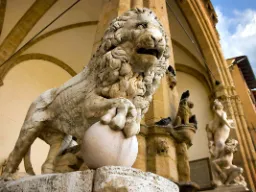 Rzeźba lwa z marmuru otoczona artystycznymi detaljami