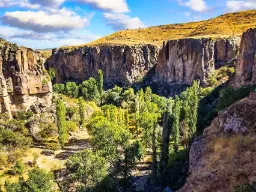Dolina Ihlara ze stromymi ścianami skalnymi i bujną zieloną przyrodą