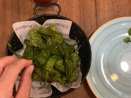 Więcej tapas - Pimientos de Padrón - małe zielone papryczki smażone w oliwie i posypane solą morską Więcej tapas - Pimientos de Padrón - małe zielone papryczki smażone w oliwie i posypane solą morską