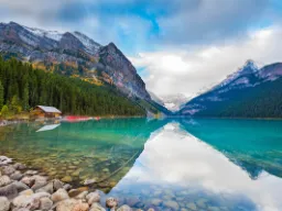 Zachwycająca przyroda nad Lake Louise z zalesionymi zboczami gór w Parku Narodowym Banff, Alberta Zachwycająca przyroda nad Lake Louise z zalesionymi zboczami gór w Parku Narodowym Banff, Alberta