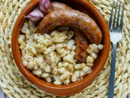 Butifarra to tradycyjna katalońska świeża kiełbasa, często robiona z wieprzowiny, podawana z białą fasolą, czosnkiem i pietruszką Butifarra to tradycyjna katalońska świeża kiełbasa, często robiona z wieprzowiny, podawana z białą fasolą, czosnkiem i pietruszką