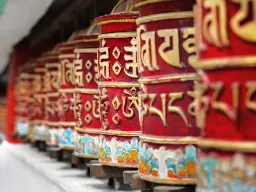 Młyn modlitewny obracany zgodnie z ruchem wskazówek zegara podczas modlitwy Młyn modlitewny obracany zgodnie z ruchem wskazówek zegara podczas modlitwy