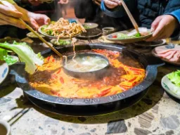 Klasyczny chiński hotpot – wspólne przygotowywanie posiłków przy stole w gotującym się bulionie