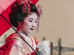 Piękna maiko (uczennica gejszy) w tradycyjnym kimonie z parasolką