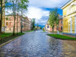 Brukowana ulica w Daugavpils, Łotwa – nastrojowa sceneria miejska z historycznymi budynkami Brukowana ulica w Daugavpils, Łotwa – nastrojowa sceneria miejska z historycznymi budynkami