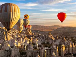 Balony nad unikalnym krajobrazem skalnym Kapadocji o wschodzie słońca