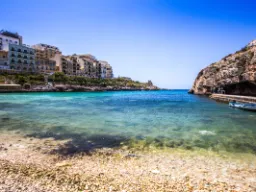 Krystalicznie czysta woda i domy nadmorskie w Xlendi Bay na Gozo Krystalicznie czysta woda i domy nadmorskie w Xlendi Bay na Gozo