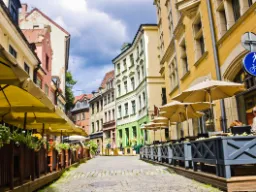 Nastrojowa ulica z kawiarniami i kolorowymi domami w starej Rydze Nastrojowa ulica z kawiarniami i kolorowymi domami w starej Rydze