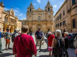 Przewodnik przy pracy w Mdinie, dawnej stolicy Malty, przed imponującą katedrą św. Pawła Przewodnik przy pracy w Mdinie, dawnej stolicy Malty, przed imponującą katedrą św. Pawła