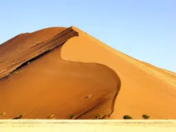 Jedna z kultowych czerwonych wydm Sossusvlei majestatycznie wznosi się ku czystemu niebu