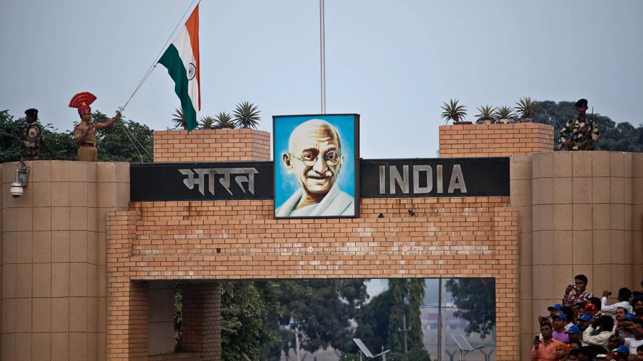 Indyjski posterunek graniczny na granicy Wagah między Indiami a Pakistanem z portretem Mahatmy Gandhiego i flagą Indii Indyjski posterunek graniczny na granicy Wagah między Indiami a Pakistanem z portretem Mahatmy Gandhiego i flagą Indii