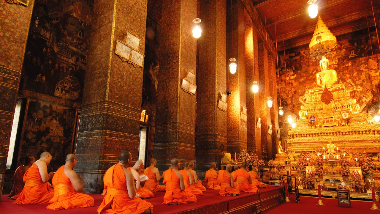 Mnisi modlący się przed Złotym Buddą w świątyni Wat Pho, Bangkok