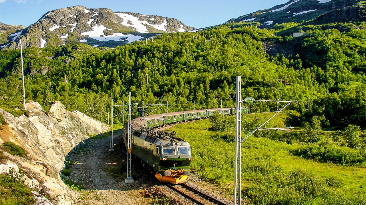 Kolej Flåmsbana wije się przez bujny norweski krajobraz górski Kolej Flåmsbana wije się przez bujny norweski krajobraz górski