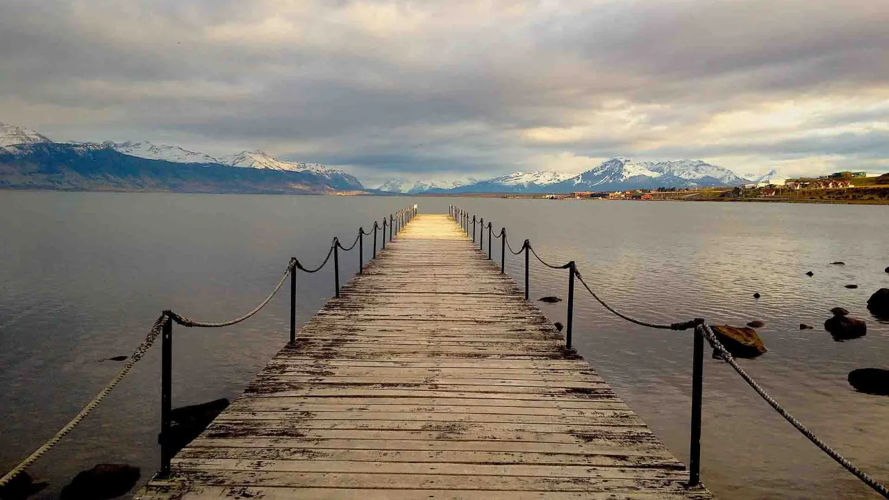 Z drewnianego mostu w Puerto Natales roztacza się widok na fiord Última Esperanza i okoliczne góry Z drewnianego mostu w Puerto Natales roztacza się widok na fiord Última Esperanza i okoliczne góry