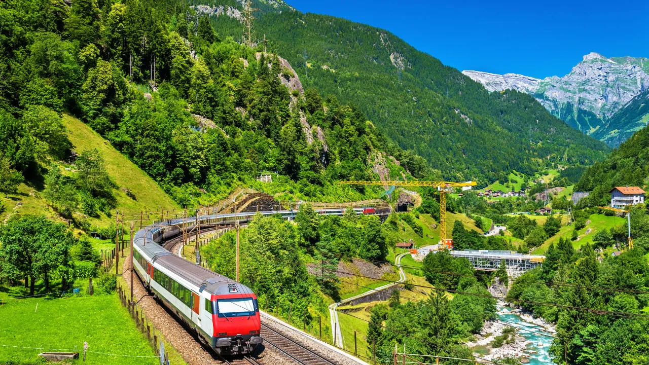 Pociąg na linii Gotthard przez bujną alpejską dolinę