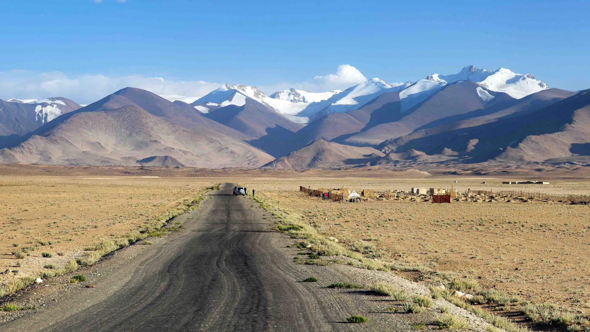 Odludny i surowy odcinek słynnej Pamir Highway z ośnieżonymi szczytami Tadżykistanu w tle Odludny i surowy odcinek słynnej Pamir Highway z ośnieżonymi szczytami Tadżykistanu w tle