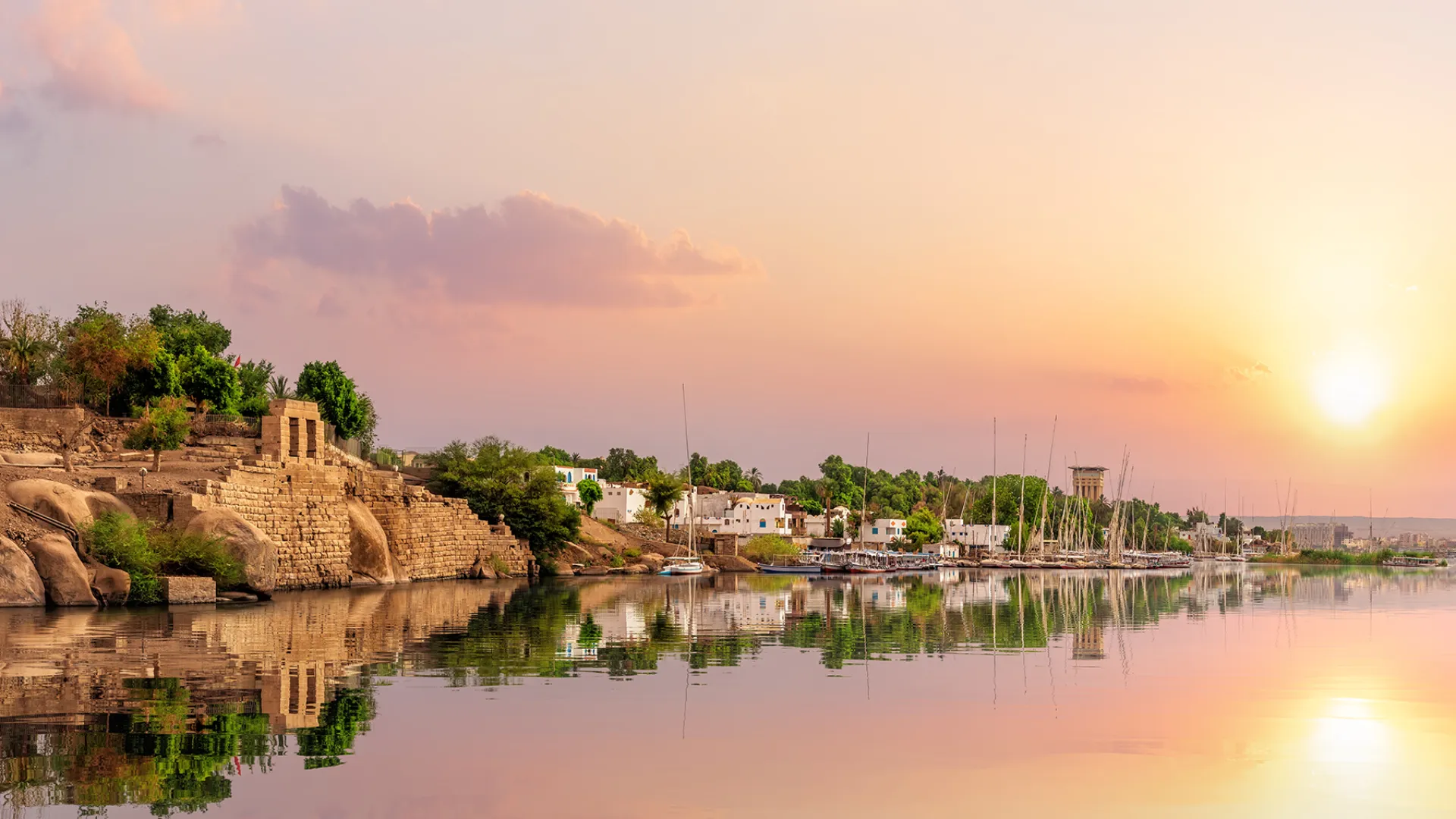 Nastrojowe zdjęcie z okolic Asuanu o zachodzie słońca z łodziami felukka